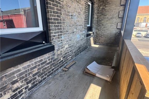 A bathroom with a toilet and a bathtub with a showerhead and tiled walls. - 92 Alfred Street Unit# 4, Brantford