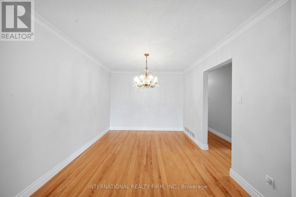 Empty dining room with hardwood floors and a crystal chandelier. - 92 Andrew Park, Vaughan
