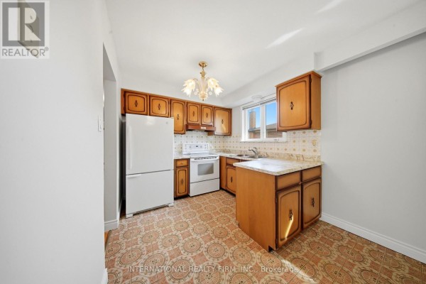Compact kitchen with wood cabinets, white appliances, and patterned flooring. - 92 Andrew Park, Vaughan