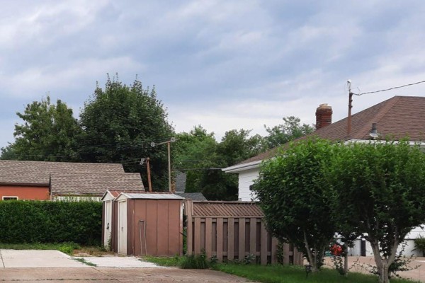 Backyard view of a shed, wooden fence, and mature trees. - Lower - 92 Margery Avenue, St  Catharines