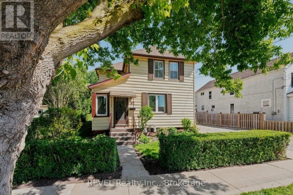 Front entrance of a two-story house with a concrete walkway leading to steps and a small porch. - 92 Saint Arnaud Street, Port Colborne