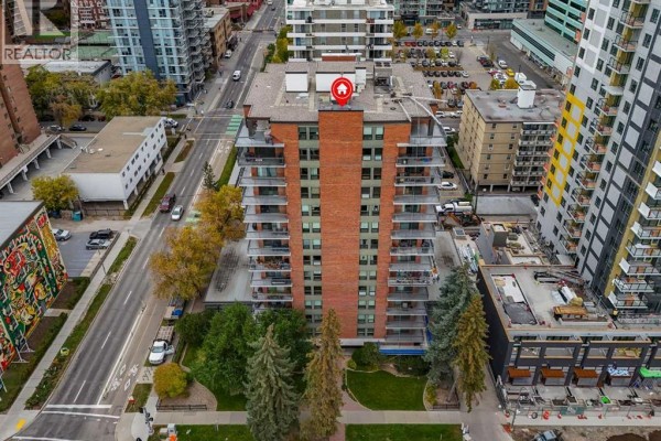 Aerial view of a brick apartment building with balconies and surrounding city streets. - 920, 540 14 Avenue Sw, Calgary