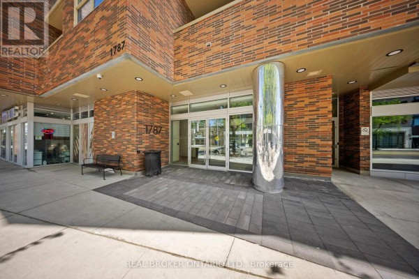 Balcony with glass railing overlooking residential rooftops and a distant cityscape. - 920 - 1787 St Clair Avenue W, Toronto