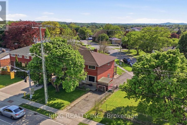 Elevated view of a red house with surrounding trees and suburban neighborhood. - 920 Concession Road, Cambridge