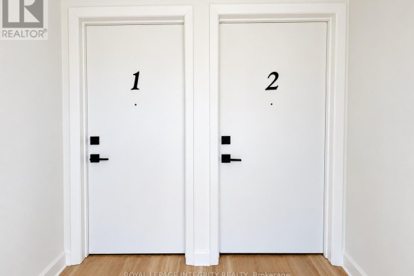 Two white doors with black hardware are side by side in a hallway, labeled '1' and '2'. - 920 Gladstone Avenue, Ottawa