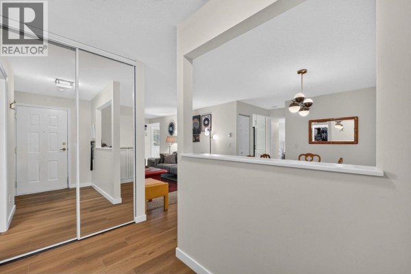 Apartment entryway with large mirrored closet doors and view into living and dining areas. - 920 Glenwood Avenue Unit# 208, Kelowna