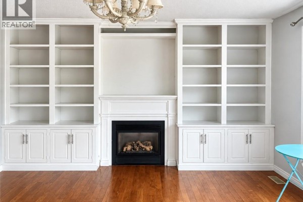 Living room with dark gray walls, hardwood floors, and bay windows. - 920 Marl Meadow Court, Kitchener