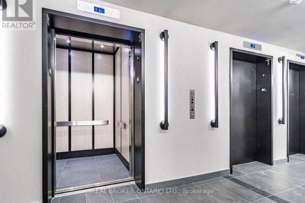 Modern apartment building lobby with marble reception desk and contemporary lighting. - 922 - 1 Jarvis Street E, Hamilton