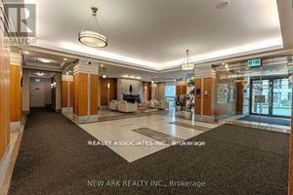 Another view of the apartment lobby, featuring seating, columns, and a glass-enclosed entrance. - 922 - 30 Clegg Road, Markham
