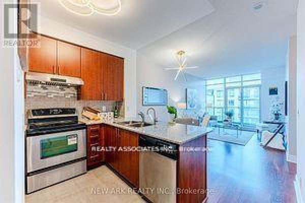 A kitchen with dark wood cabinets, stainless steel appliances, and a breakfast bar. - 922 - 30 Clegg Road, Markham