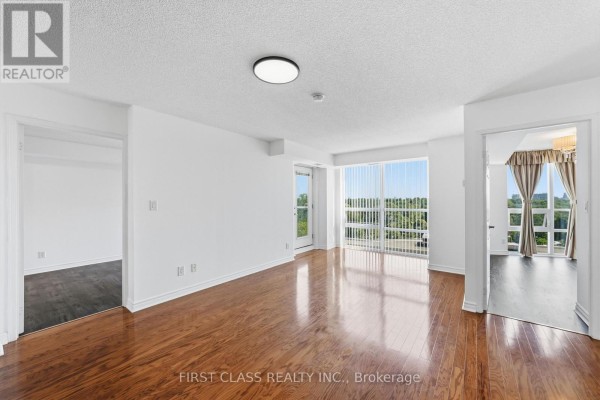 Living area with hardwood floors, white walls, and access to other rooms. - 922 - 35 Hollywood Avenue, Toronto