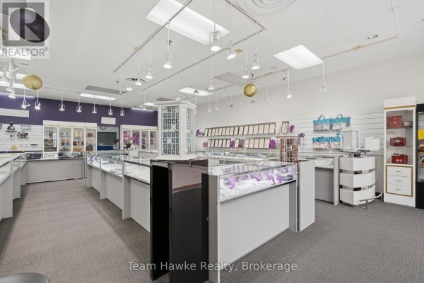 View of a jewelry store's display cases filled with merchandise, under bright interior lighting. - 9225 County 93 Road, Midland