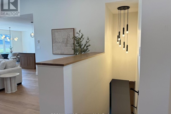 Living room with a tall stone fireplace, grey walls, and wood bench seating. - 926 Bogdanovic Way, Huron Kinloss