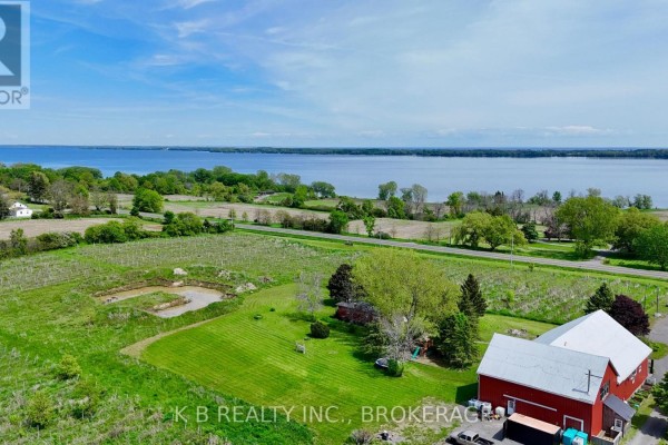 Aerial view of rural property with vineyards, red buildings, and a large body of water. - 9261 Loyalist Parkway, Greater Napanee