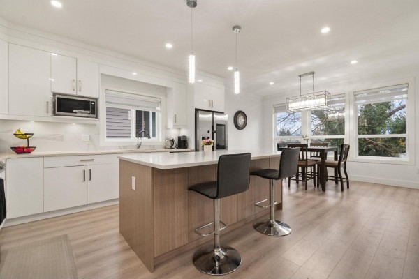 Modern kitchen with island, stainless steel appliances, and dining area - 9262 Sitka Place, Chilliwack Proper East, Chilliwack