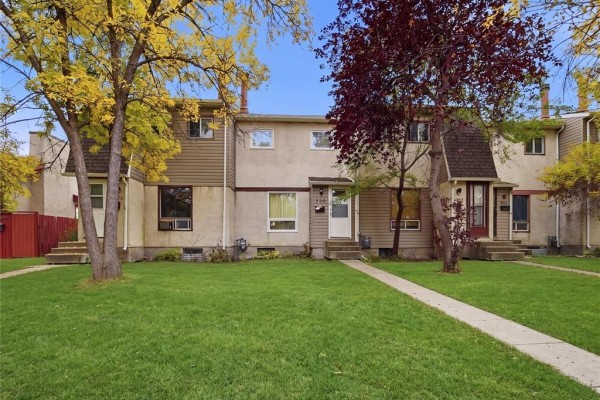 A row of multi-family homes with beige and brown exteriors, white doors, and green lawns. - 928 Greencrest Avenue, Winnipeg
