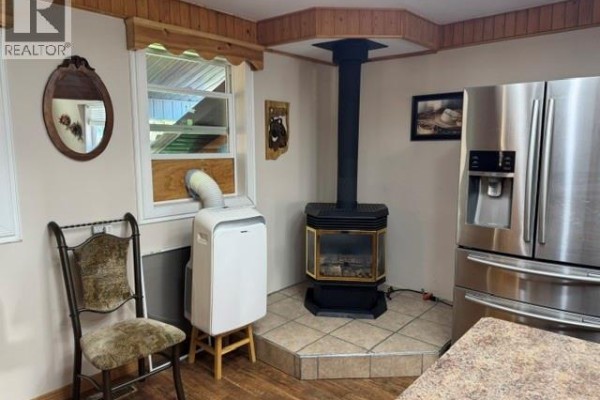 Open kitchen with stainless steel appliances, wooden cabinets, and a large island. - 928 Lakeshore Dr., Turtle Lake