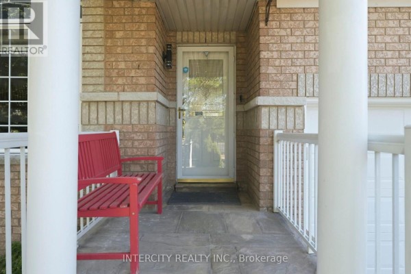 Red wooden bench on the front porch with white railings and a glass-paneled front door. - 93 Chalone Crescent, Vaughan