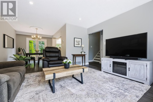 Living room with a TV, leather recliner, dining area, and staircase. - 93 Church Street, Orangeville