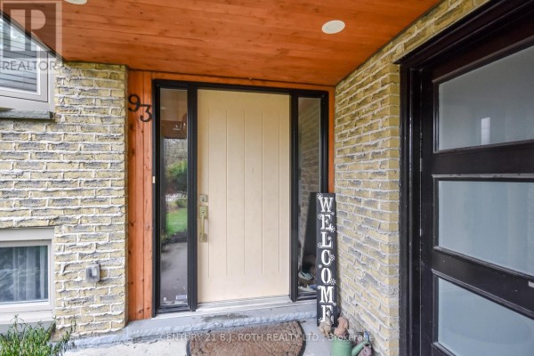 Front entranceway with a beige door, glass side panels, and the house number "93". - 93 Grove Street E, Barrie