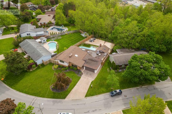 Aerial view of a large bungalow property with a swimming pool, surrounded by mature trees and neighboring homes. - 93 Riverview Boulevard, St  Catharines