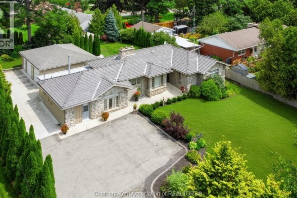 Aerial view of a stone bungalow with attached garage and large driveway. - 931 Charing Cross Road, Chatham