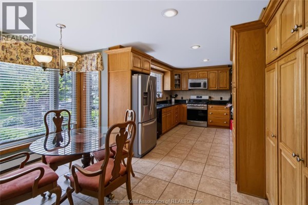 Kitchen with oak cabinets, stainless steel appliances, granite countertops, and tiled floor. - 931 Charing Cross Road, Chatham