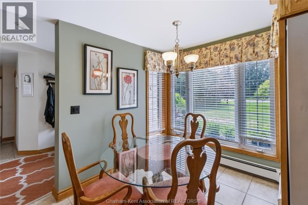 Breakfast nook with glass-top table, chairs, bay window, and garden view. - 931 Charing Cross Road, Chatham