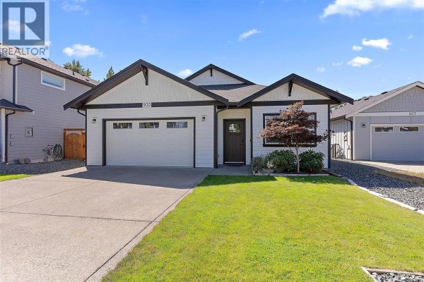 View of a backyard patio with two chairs and a table under a deck. - 933 Blakeon Pl, Langford