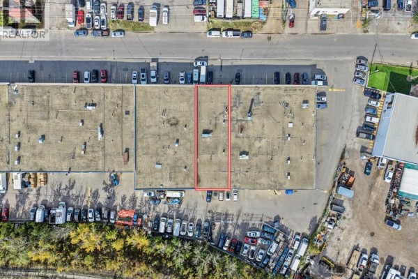 Aerial view of a commercial building complex with parking lots and surrounding industrial area. - 933a 48 Avenue Se, Calgary