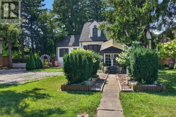 Sidewalk leading to the house entrance, flanked by manicured hedges and flower beds. - 935 Bartlet, Windsor