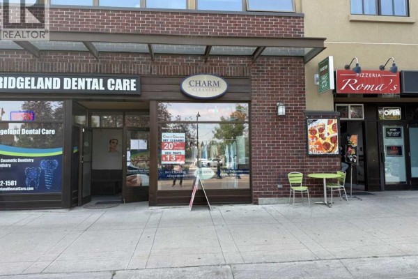 Exterior view of Charm Cleaners storefront with adjacent businesses and sidewalk seating. - 935 General Avenue Ne, Calgary