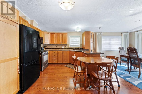 Living room with beige sofas, decorative lamp, and access to other rooms. - 936 - 316489 31st Line, Zorra