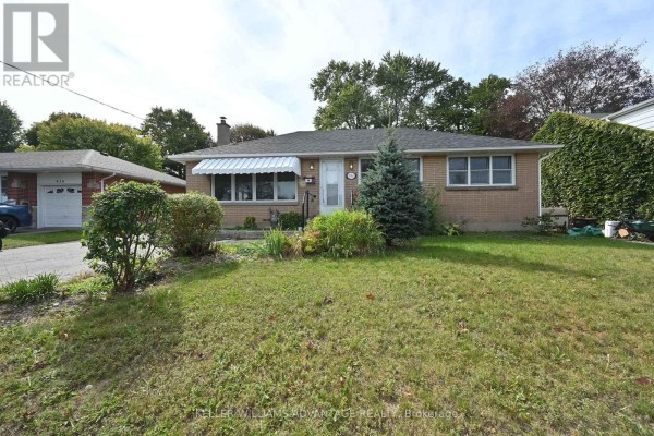 Front exterior of a brick bungalow with a well-maintained lawn and landscaping. - 936 Somerville Street, Oshawa