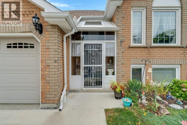 Close-up of the front door entrance with a security screen and plants. - 94 Dawn Crescent, Cambridge