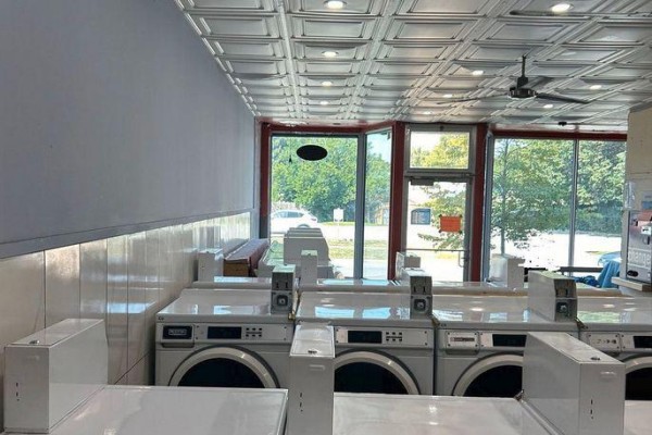 View of laundromat washers and dryers from the side, with large windows overlooking the street. - 94 Lake Street, St  Catharines
