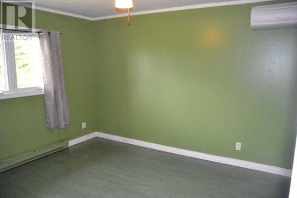 Bedroom with light green walls, green floor, a window with grey curtains, and an air conditioner. - 94 Main Road, Aquaforte