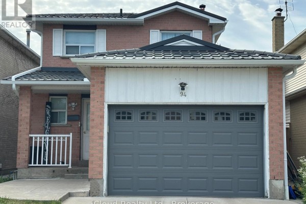 Close-up exterior view of a two-story brick house with a white facade above the garage and house number 94. - 94 Newbridge Crescent, Brampton