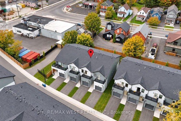 Aerial view of a row of modern townhouses with driveways and green lawns. - 94 Sunshine Lane, Orillia