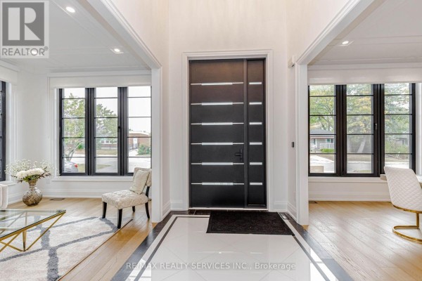 Entrance foyer with a black front door, large windows, and hardwood floors. - 94 Vista Boulevard, Mississauga