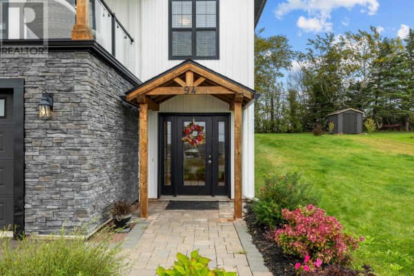 Close-up of the entrance with a wooden covered porch, glass-paneled double doors, and wreath. - 94 Water's Edge Lane, Cornwall