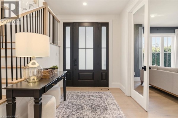 Master bedroom with a bed, large windows, and built-in wardrobes, featuring neutral decor. - 940 Gorton Avenue, Burlington