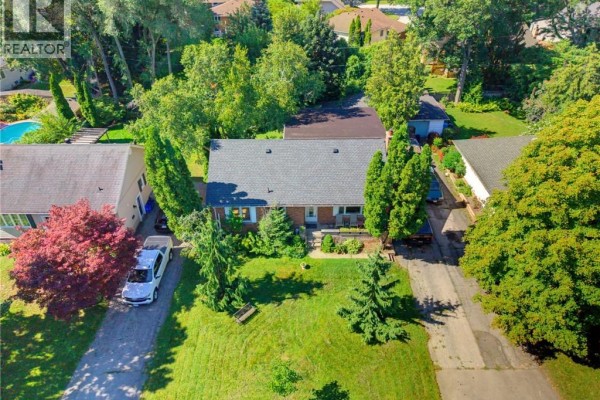 Aerial view of a property with a red brick house, driveway, and pool in adjacent yard. - 940 Harvey Place, Halton