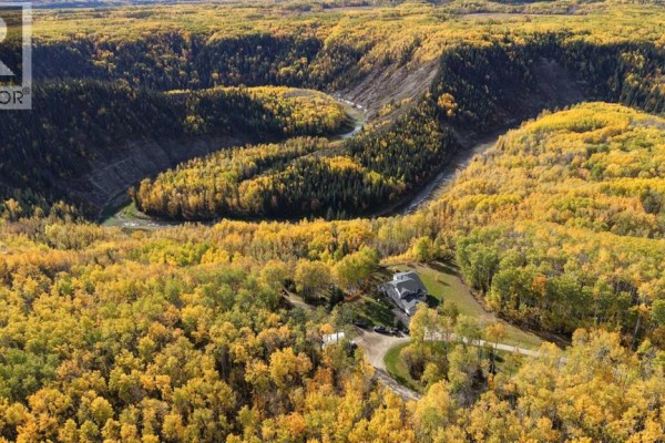 Expansive aerial view of a rural property featuring a house nestled amidst dense, colorful autumn forest. - 94038b -- 702 Township, Rural Grande Prairie No  1, County Of