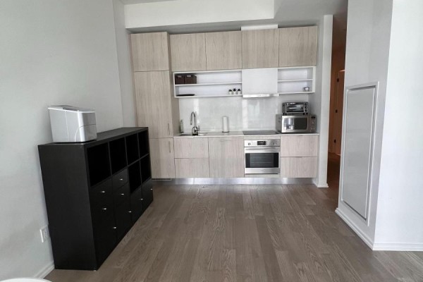 Kitchen with light wood cabinets, stainless steel appliances and grey flooring. - 943 - 8 Hillsdale Avenue E, Toronto