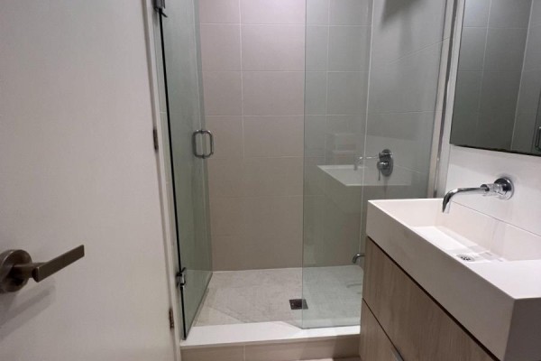 Bathroom with glass-enclosed shower, floating vanity and square tiled walls. - 943 - 8 Hillsdale Avenue E, Toronto