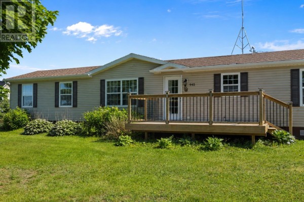 Bedroom with a double bed, pale blue walls, beige carpet, and a window with brown curtains. - 945 Newton Road, Kinkora