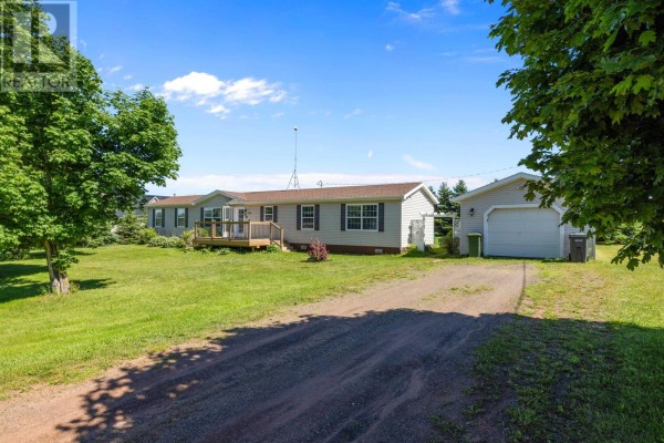 Aerial view of 945 Newton Road property including houses, barns, and fields under a blue sky. - 945 Newton Road, Kinkora