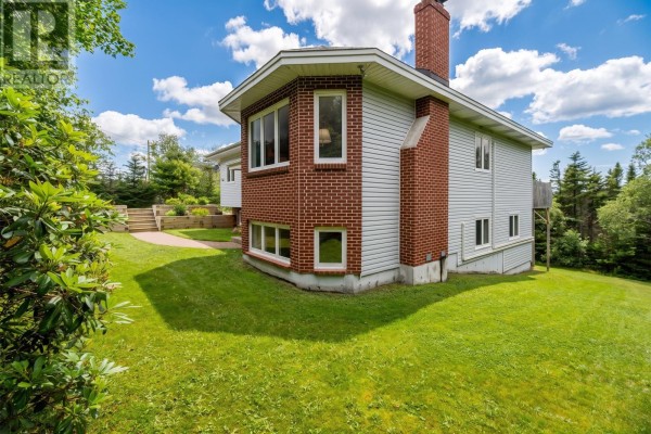 View of the house from the garden, showing a brick pathway and landscaped garden beds. - 946 Indian Meal Line, Portugal Cove   St  Phillips