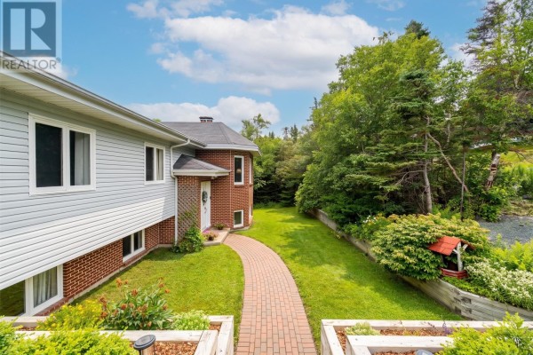 Aerial view of the residential property from the driveway, showing the house and surrounding greenery. - 946 Indian Meal Line, Portugal Cove   St  Phillips